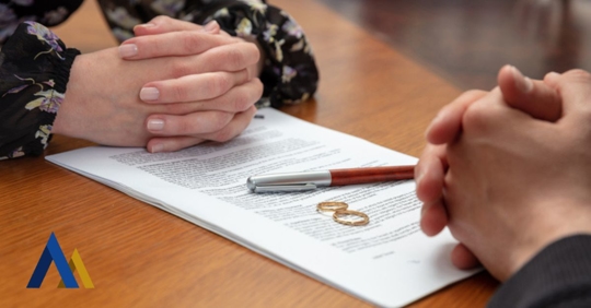 wedding rings lie on a document during divorce negotiations