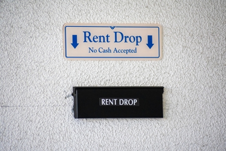 Rent Drop, No cash accepted sign with down arrow pointing to flap of secure rent drop box