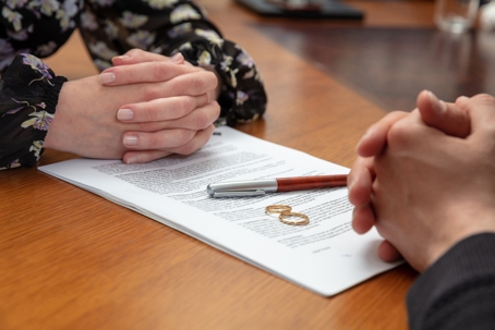 Divorce signature, marriage dissolution document. Wedding ring and agreement on lawyer office