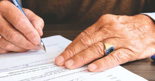 man signing paper