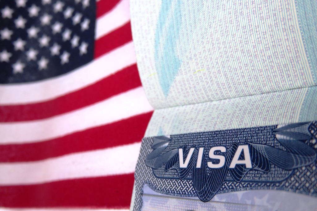 Photograph of a passport visa and an American flag.