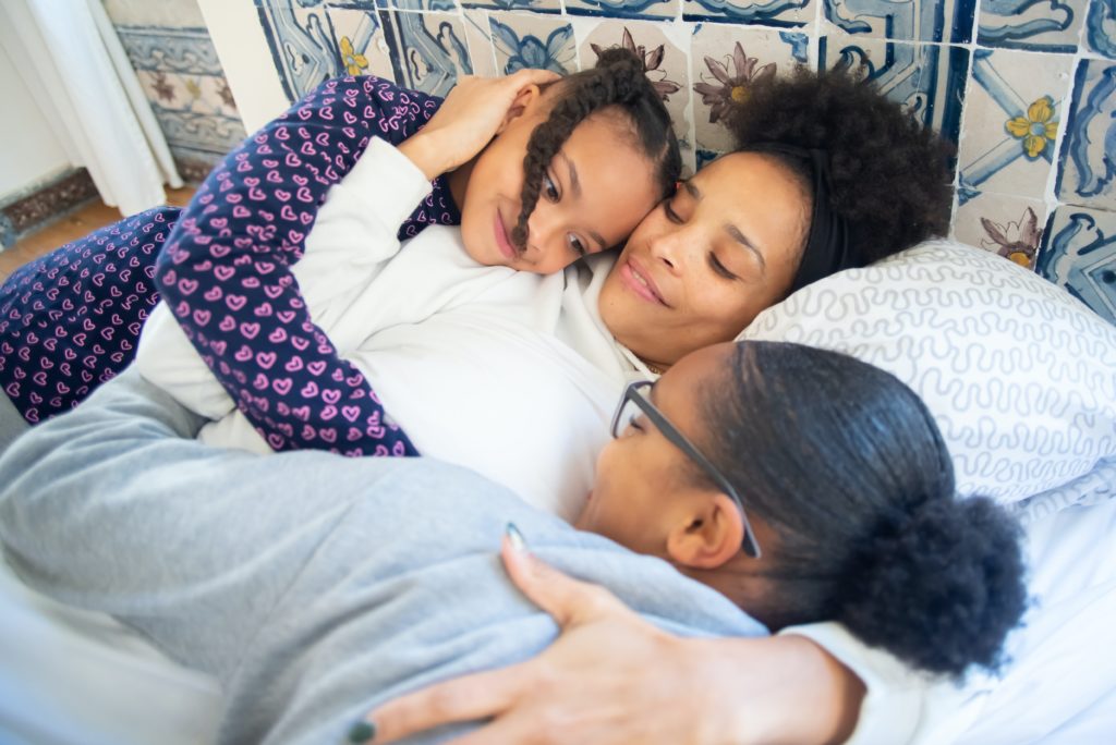 mother hugging her daughters