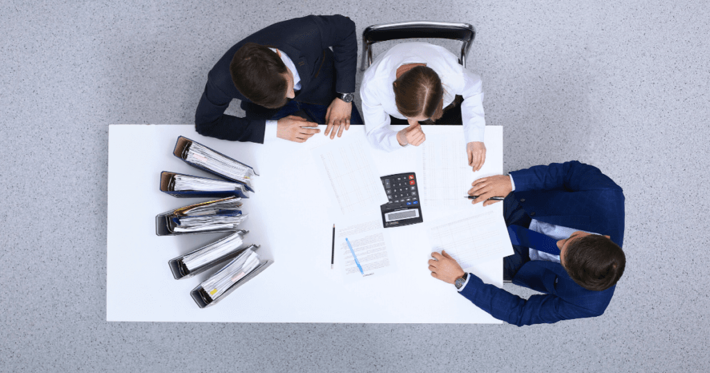 People sitting at table reviewing spreadsheets