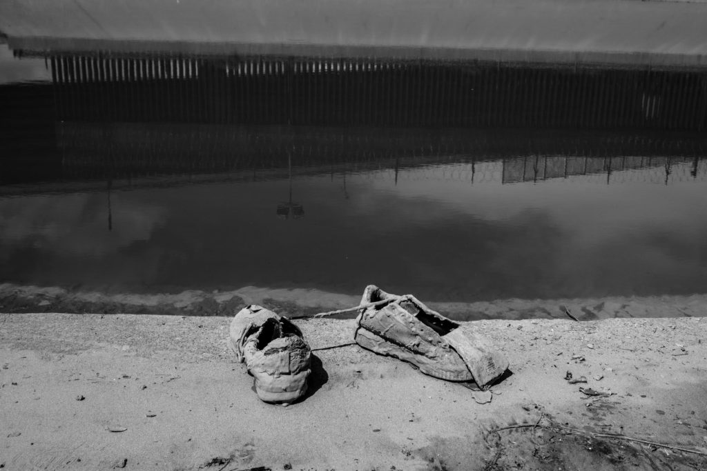 shoes on side of riverbank