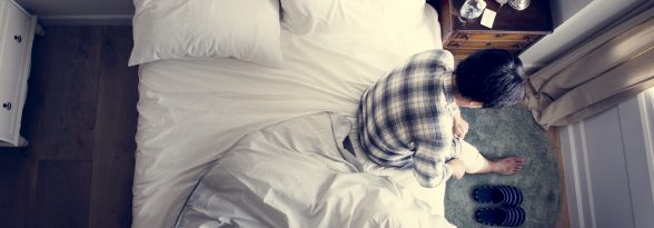 Injured Asian man sitting on the bed